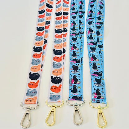 Four lanyards with cat patterns on a white background