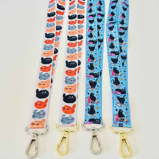 Four lanyards with cat patterns on a white background