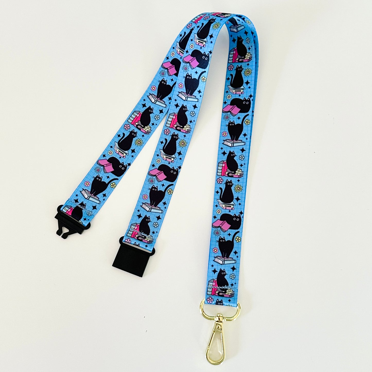 Lanyard with black cat design on a blue background