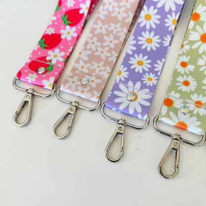 Four fabric keychains with floral patterns on a white background