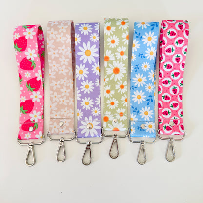 Set of six floral and strawberry patterned lanyards on a white background