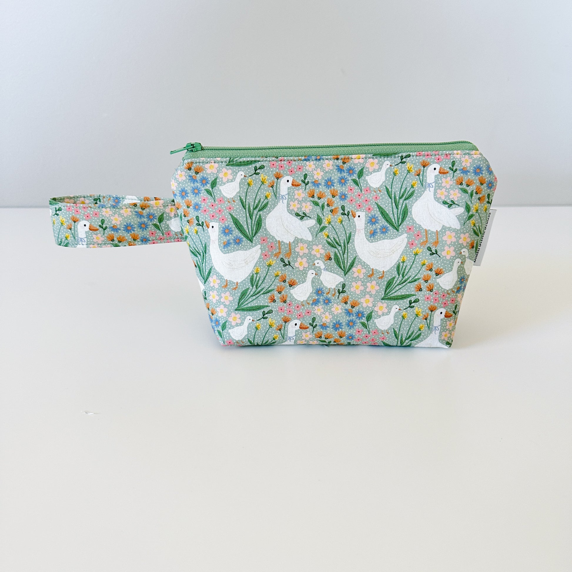 Cosmetic bag with goose and floral pattern on a white background
