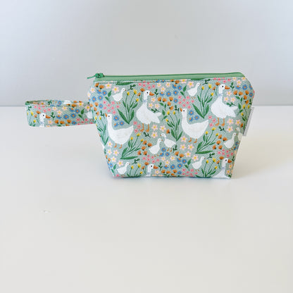 Cosmetic bag with goose and floral pattern on a white background