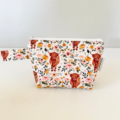 Floral pouch with highland cow design on a white background