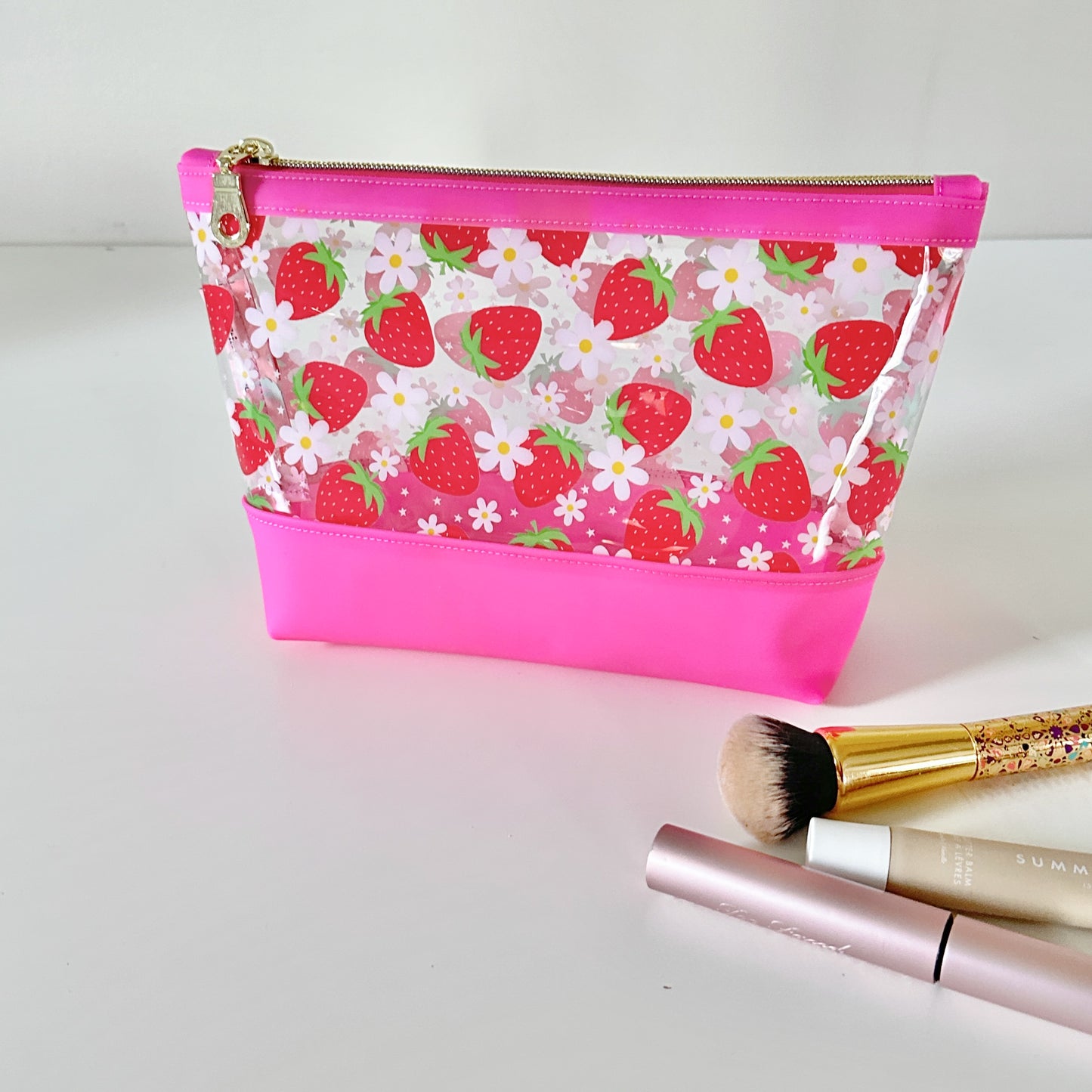 clear makeup bag with a pink strawberry pattern