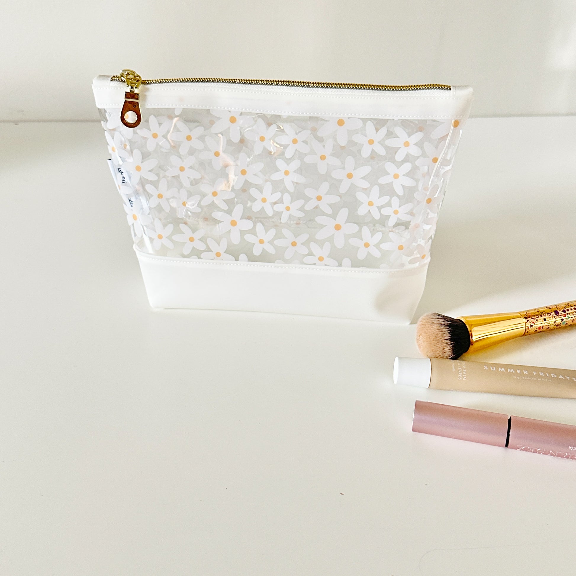 Clear pouch with white floral pattern on a light gray background