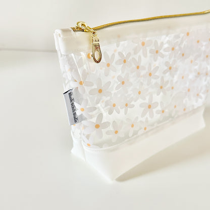 Clear pouch with white floral pattern on a light gray background