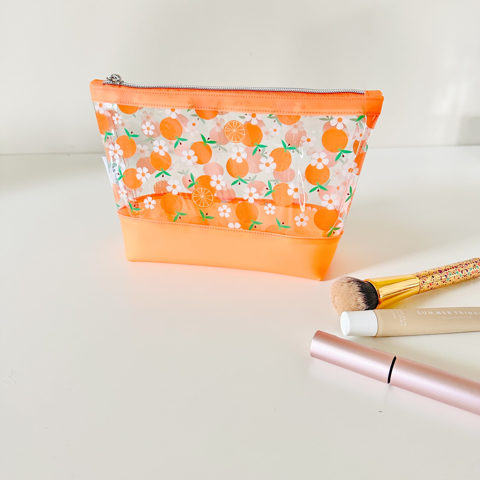 Clear pouch with white floral pattern on a light gray background