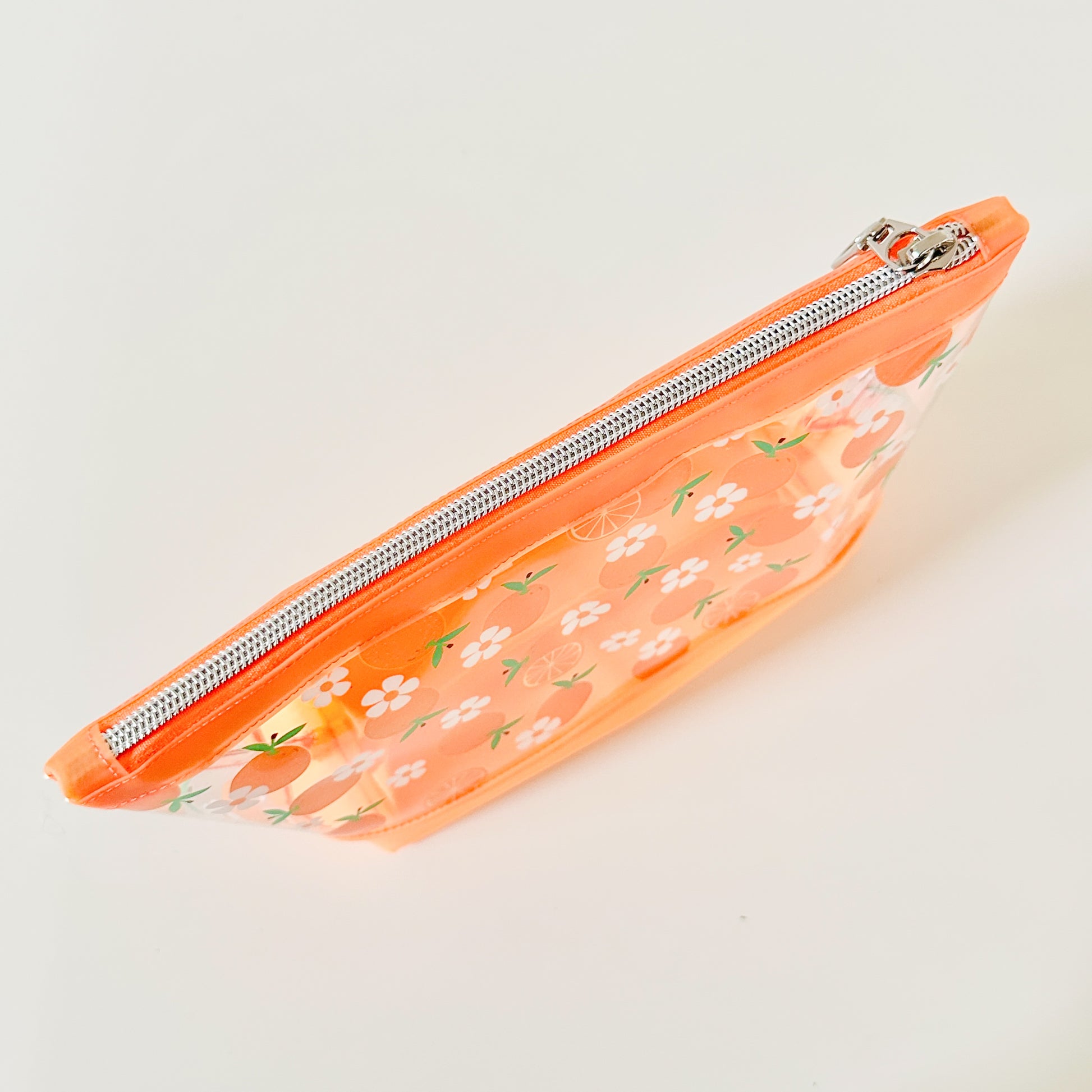 Clear pouch with white floral pattern on a light gray background