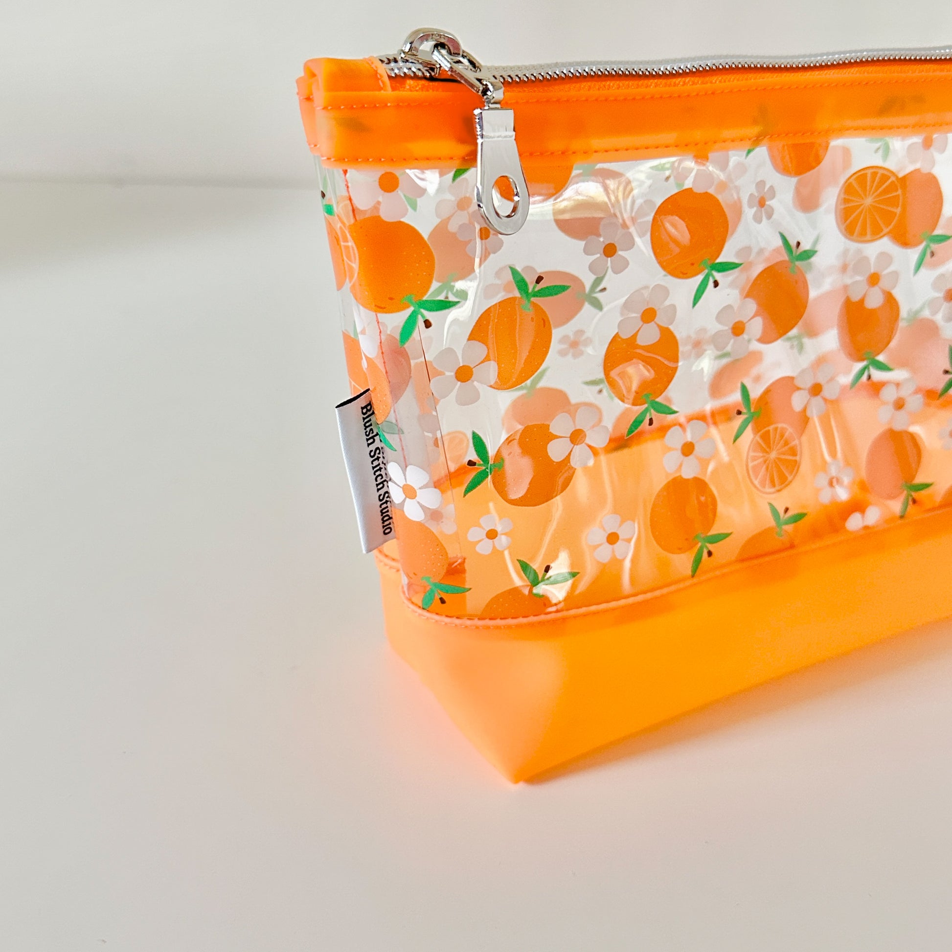 Clear pouch with white floral pattern on a light gray background
