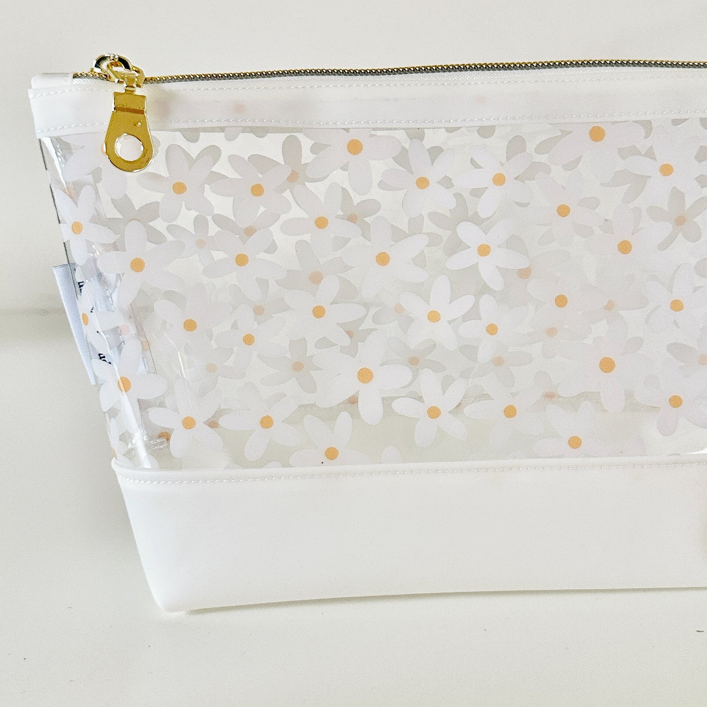 Clear pouch with white floral pattern on a light gray background