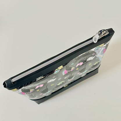 clear makeup bag with a black cat and book pattern