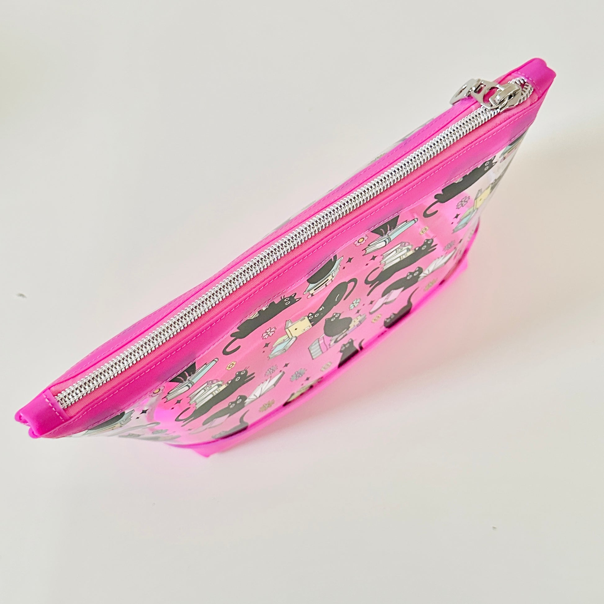 clear makeup bag with a black cat and book pattern pink bottom