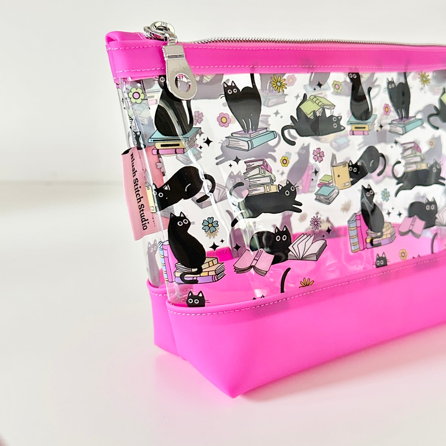 Pink cosmetic bag with black cat design on a white background