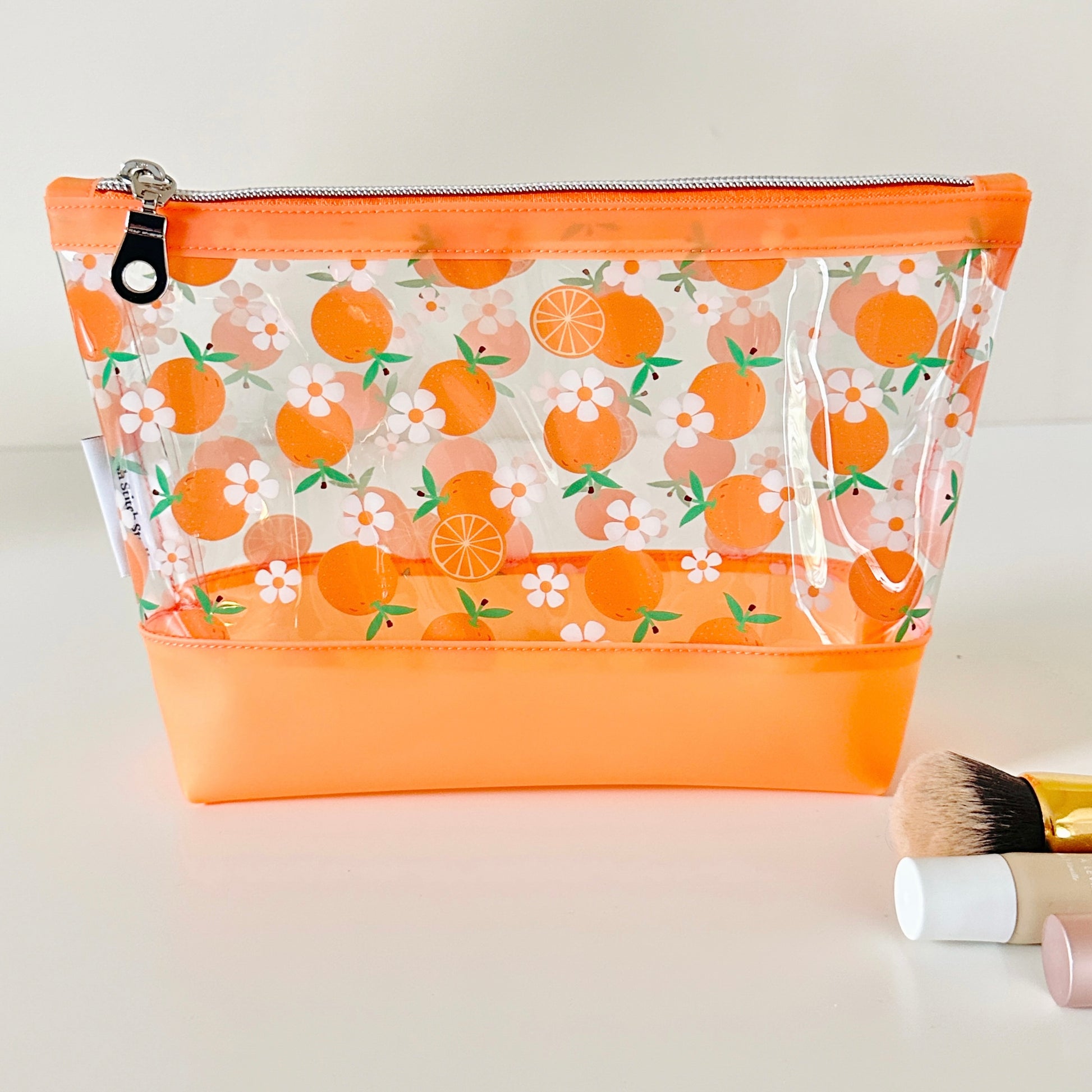 Clear makeup bag with an orange pattern on a light background