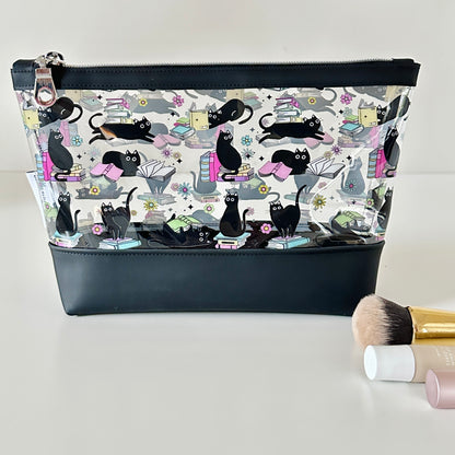 clear makeup bag with a black cat and book pattern