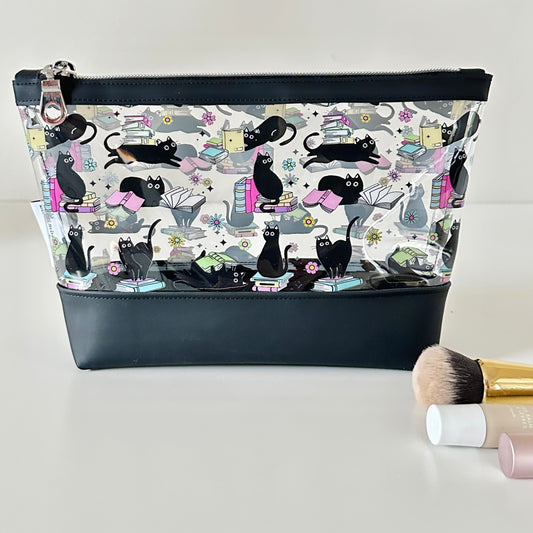 clear makeup bag with a black cat and book pattern