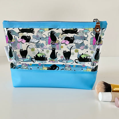 Cosmetic bag with black cat pattern and blue zipper on a white background