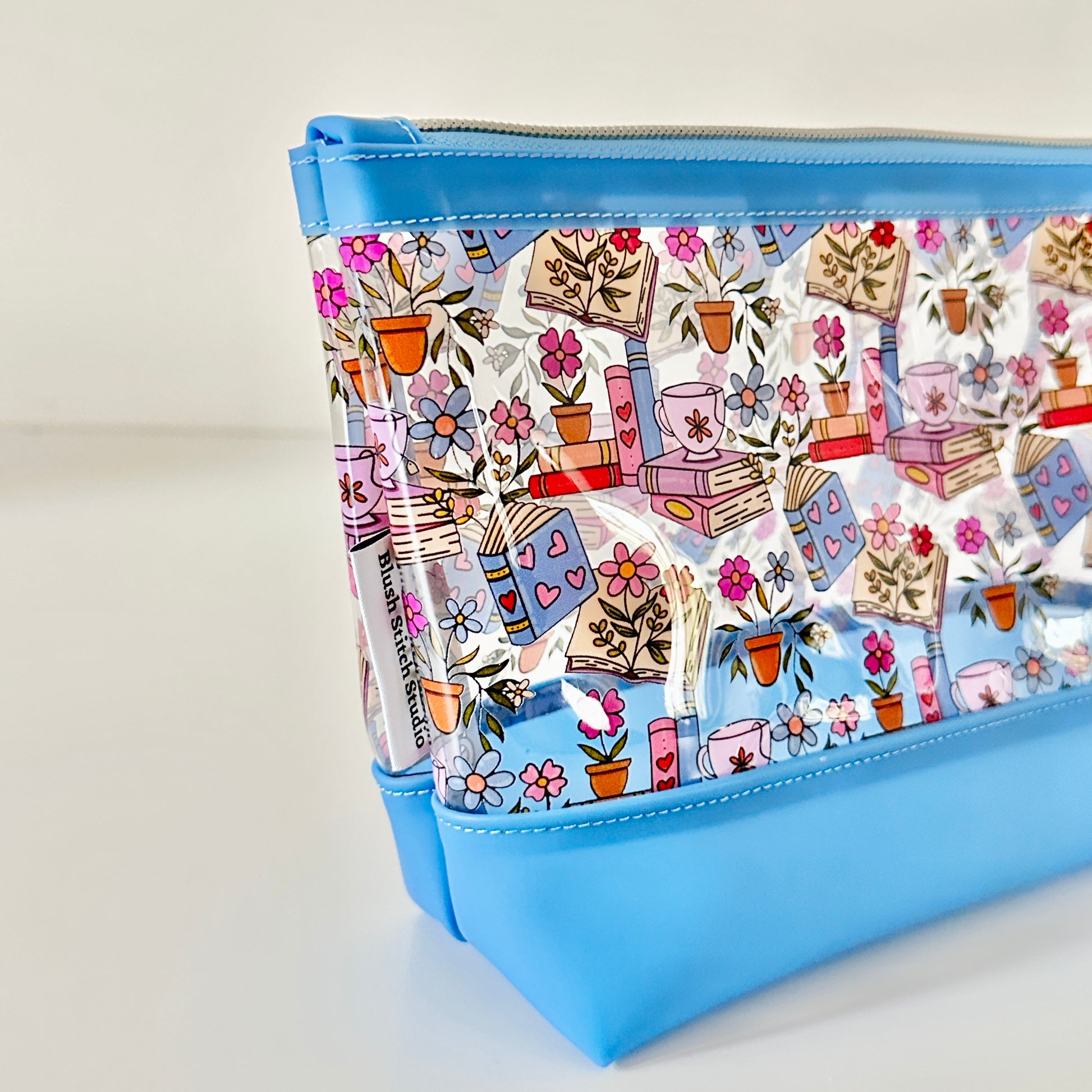 clear makeup bag with floral and book design