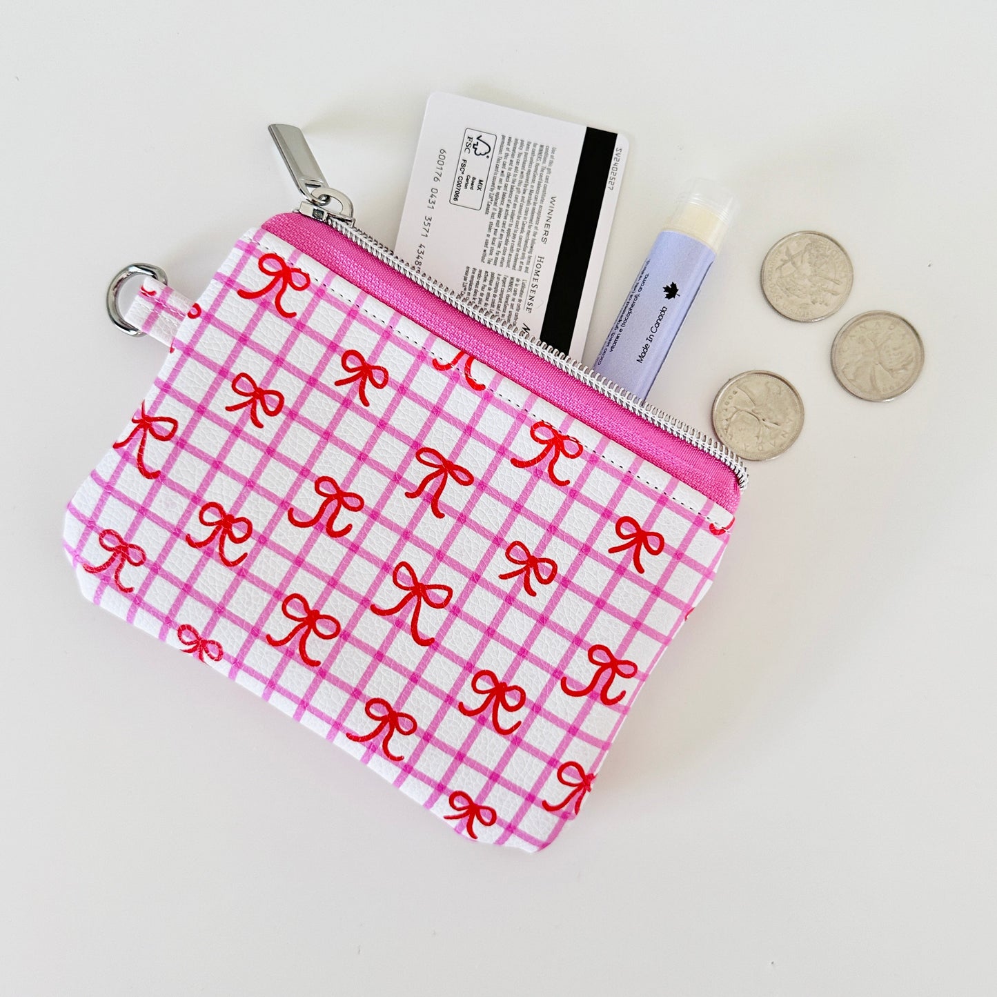 Pink checkered coquette vegan leather coin purse with red bows on a white background