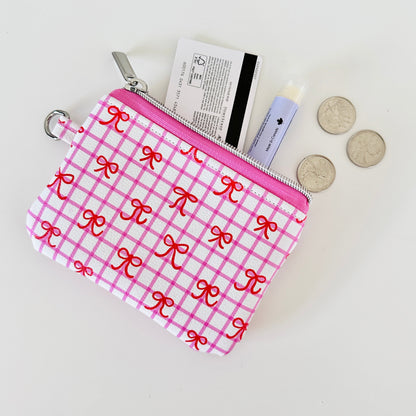 Pink checkered coquette vegan leather coin purse with red bows on a white background