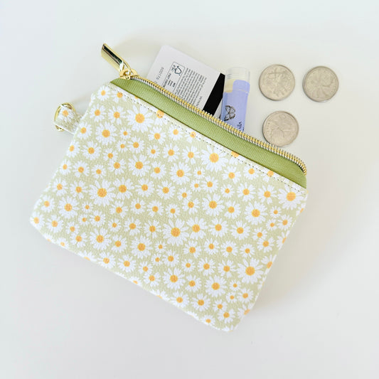 green daisy Floral-patterned coin purse  with coins and cards on a light background