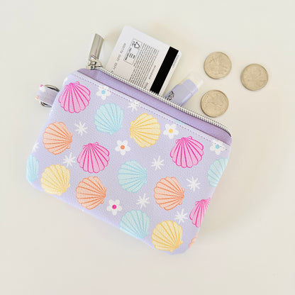 purple vegan leather coin purse with seashell pattern on a white background
