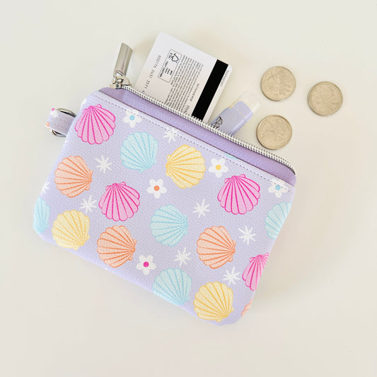 purple vegan leather coin purse with seashell pattern on a white background