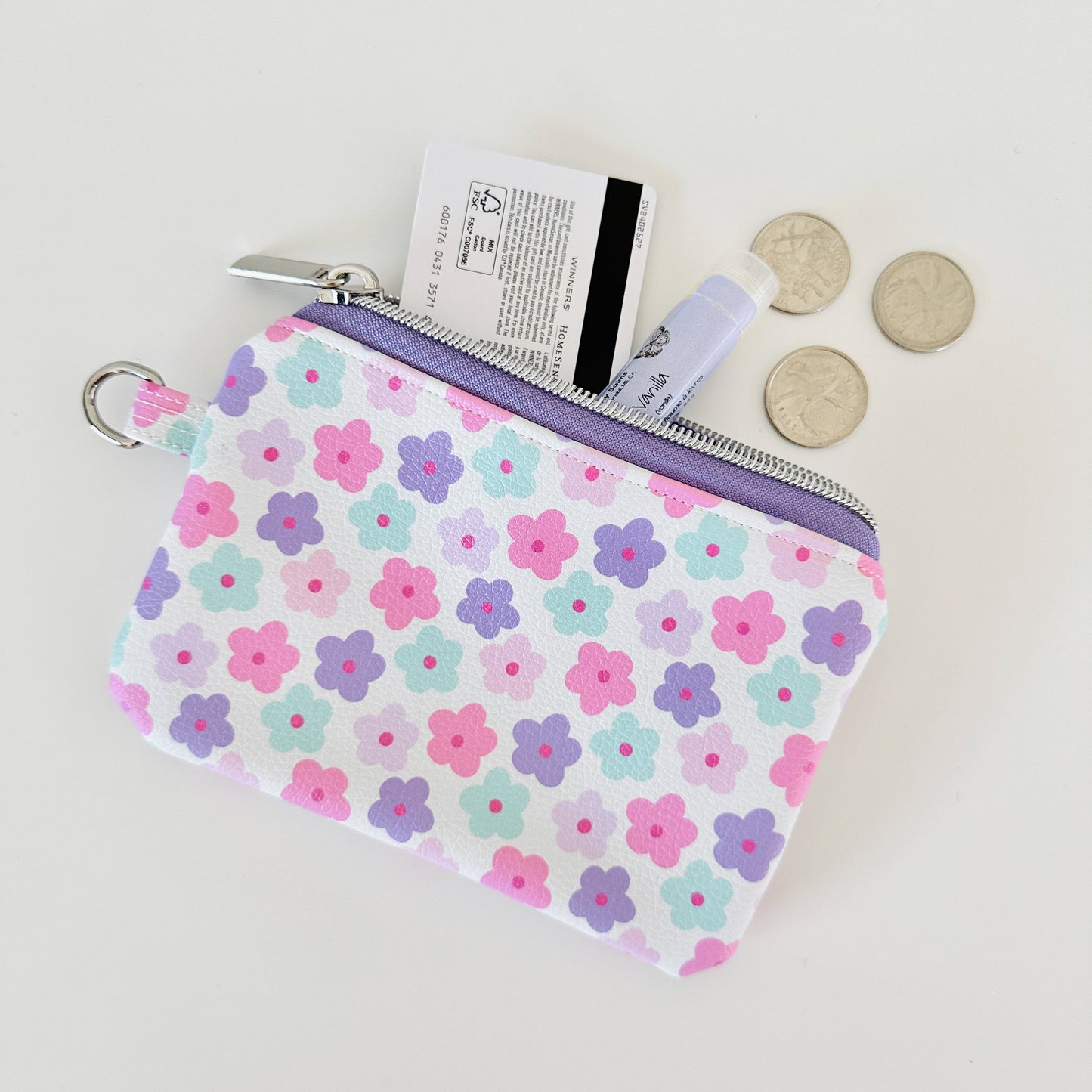 pink and purple Floral-patterned coin purse with coins and cards on a white background