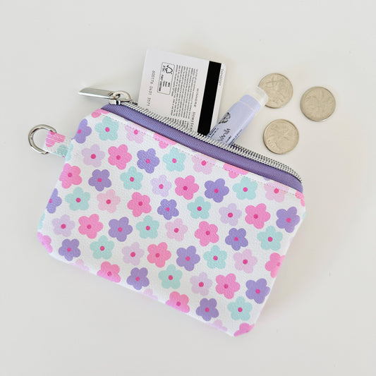 pink and purple Floral-patterned coin purse with coins and cards on a white background