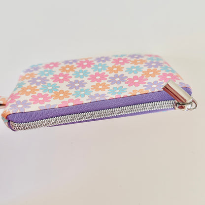 Floral patterned coin purse with cards and coins on a white background