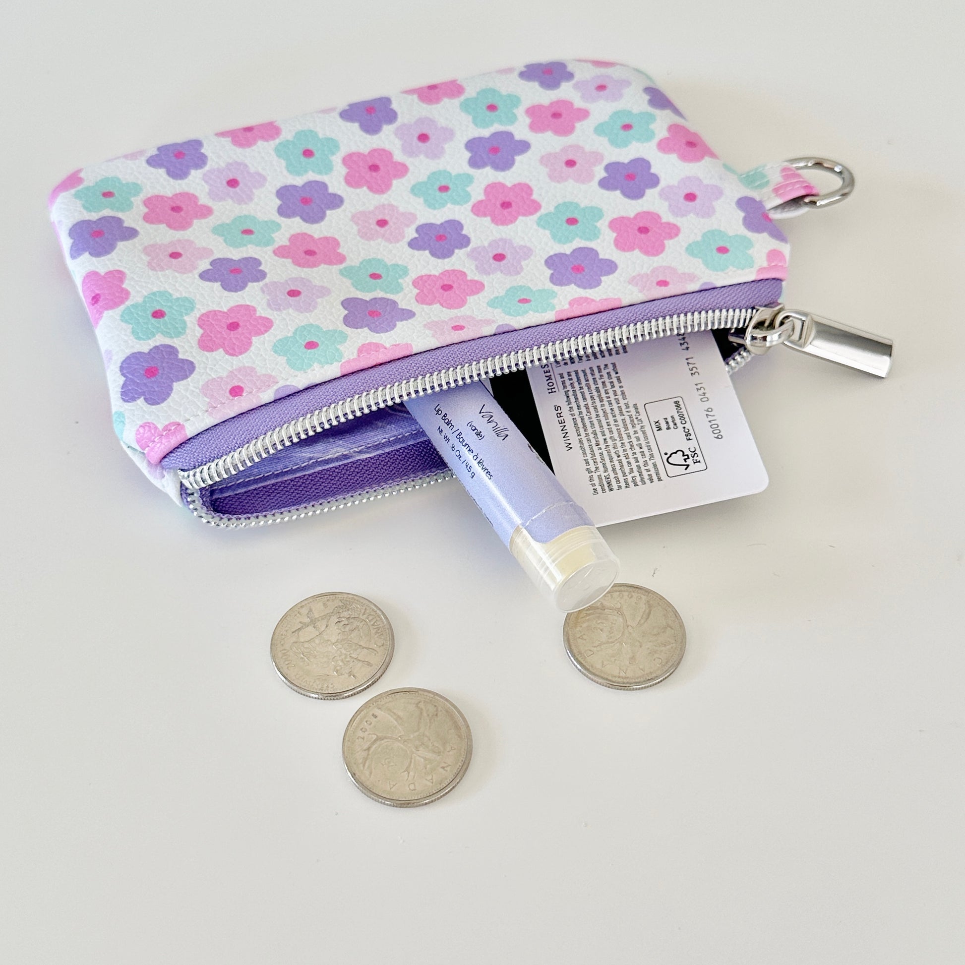 pink and purple Floral-patterned coin purse with coins and cards on a white background