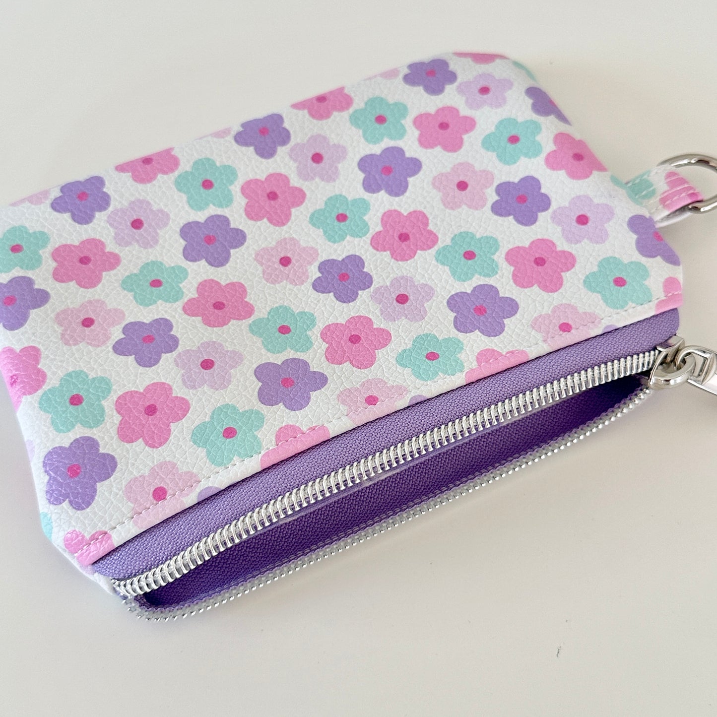 pink and purple Floral-patterned coin purse with coins and cards on a white background