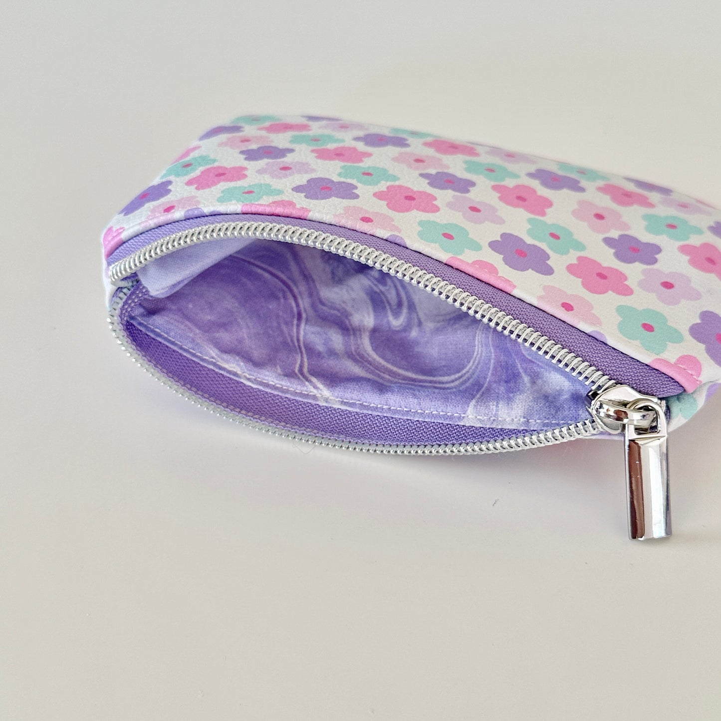 pink and purple Floral-patterned coin purse with coins and cards on a white background