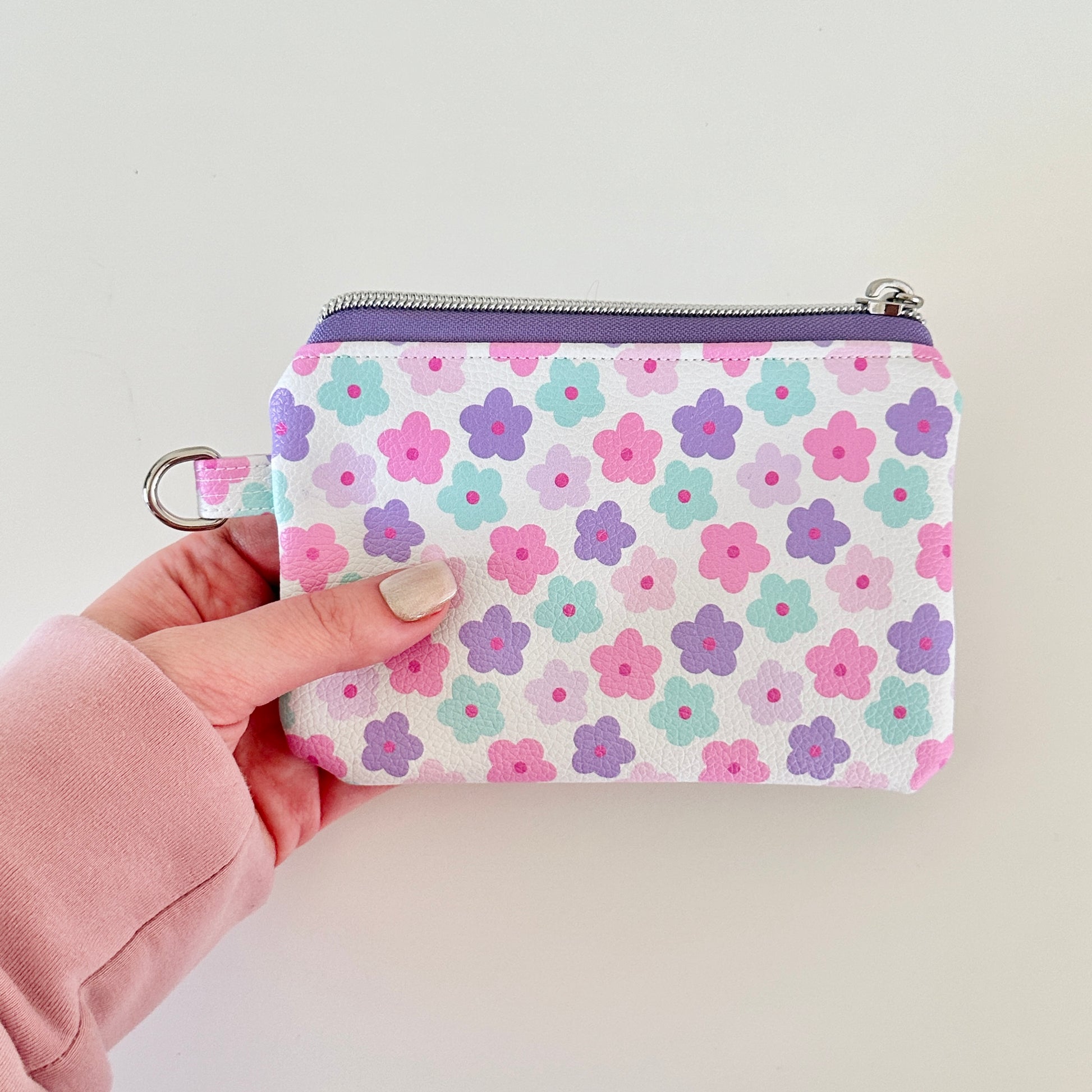 pink and purple Floral-patterned coin purse with coins and cards on a white background
