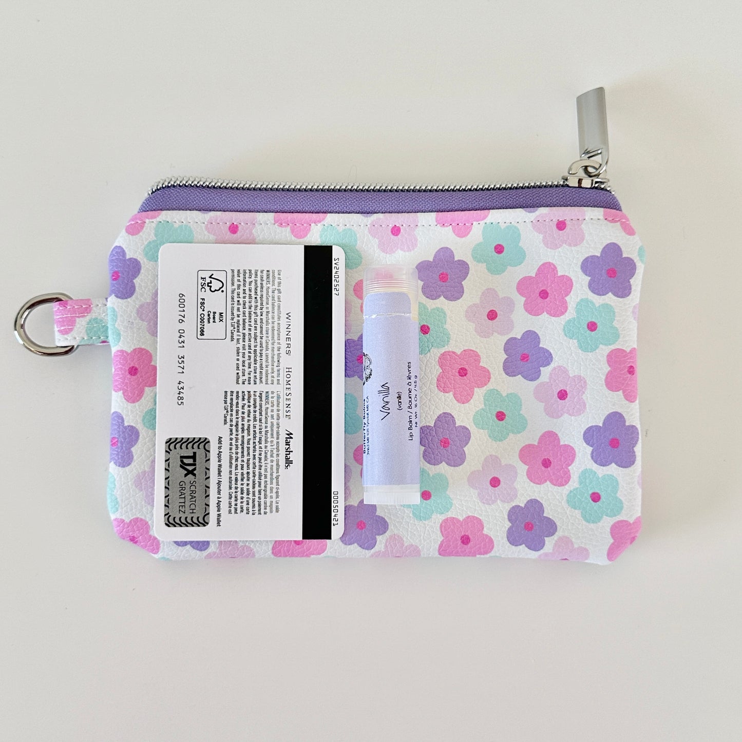 pink and purple Floral-patterned coin purse with coins and cards on a white background