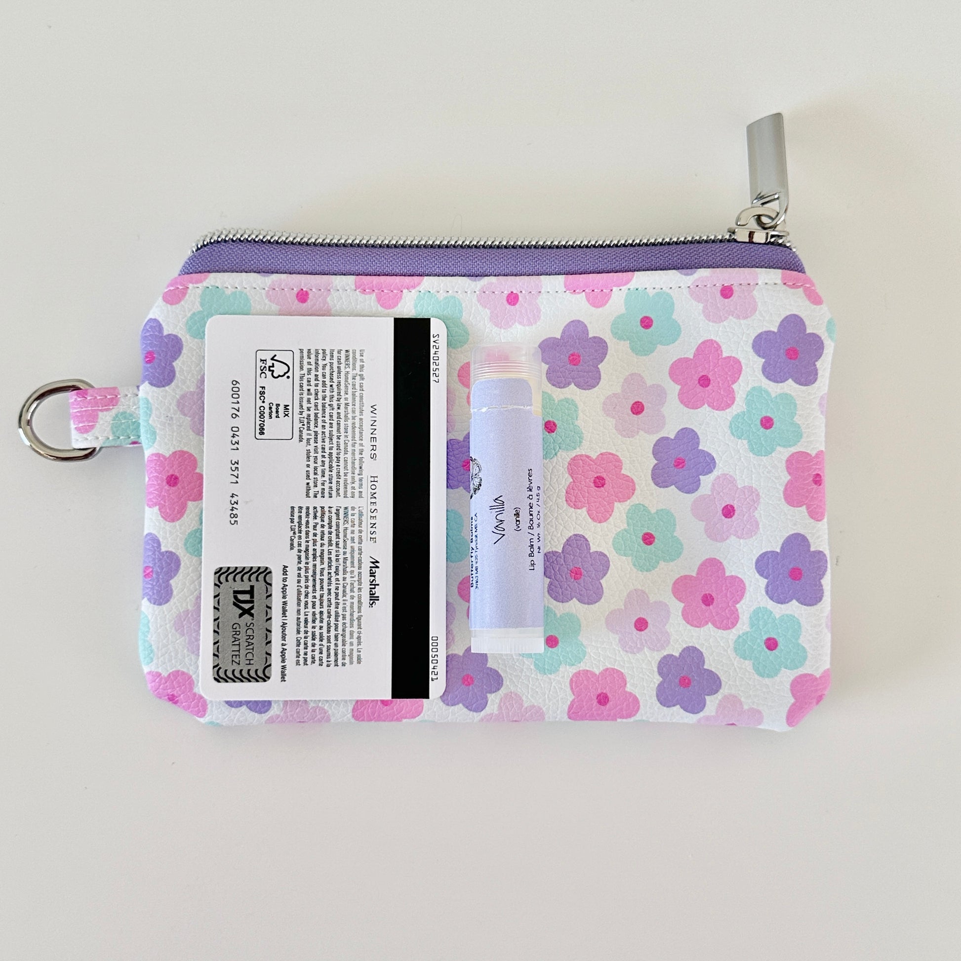 pink and purple Floral-patterned coin purse with coins and cards on a white background