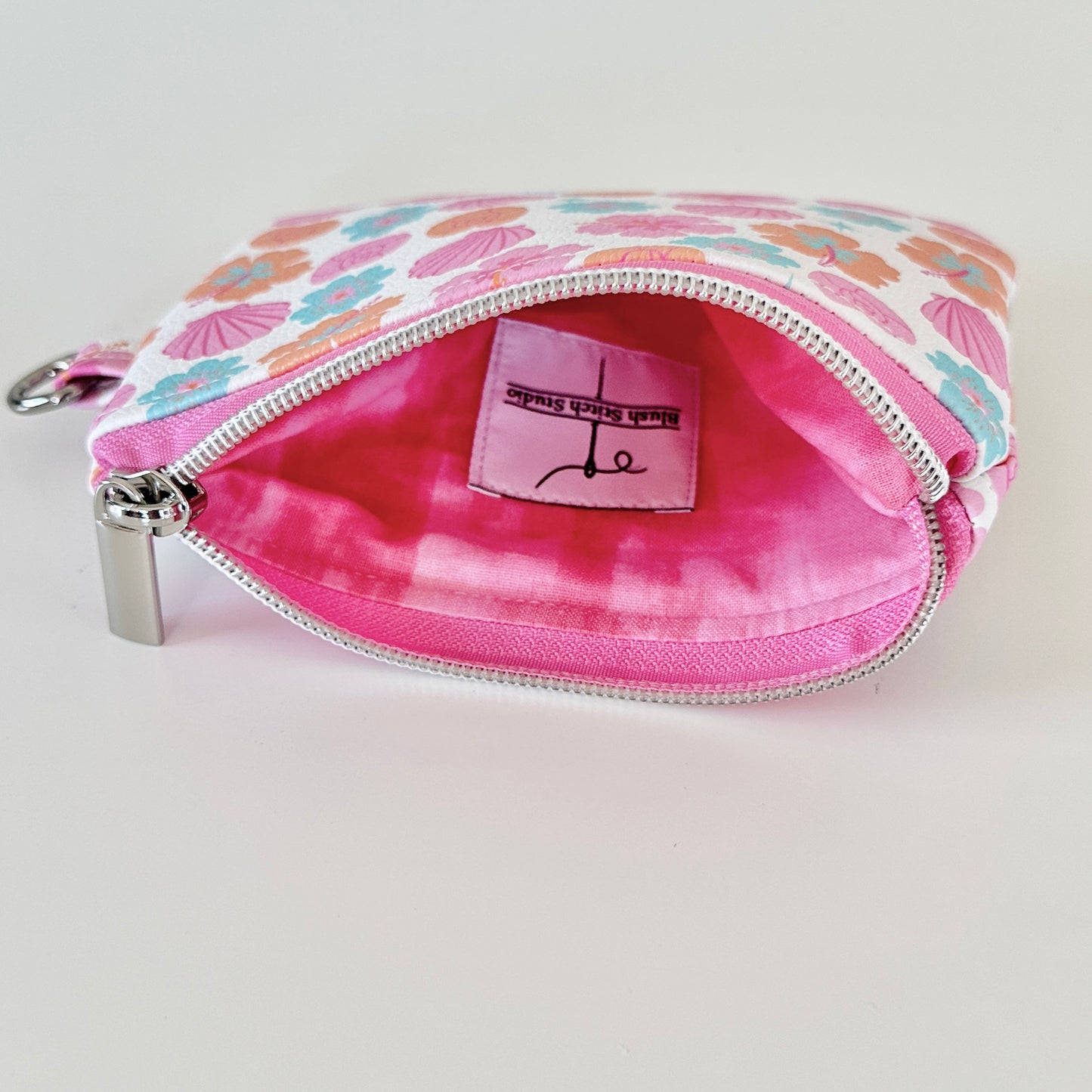 sea shell vegan leather coin purse with seashell pattern on a white background