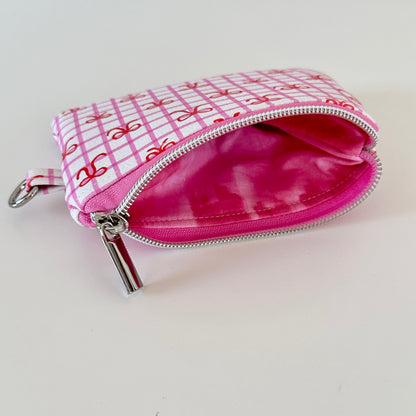 Pink checkered coquette vegan leather coin purse with red bows on a white background