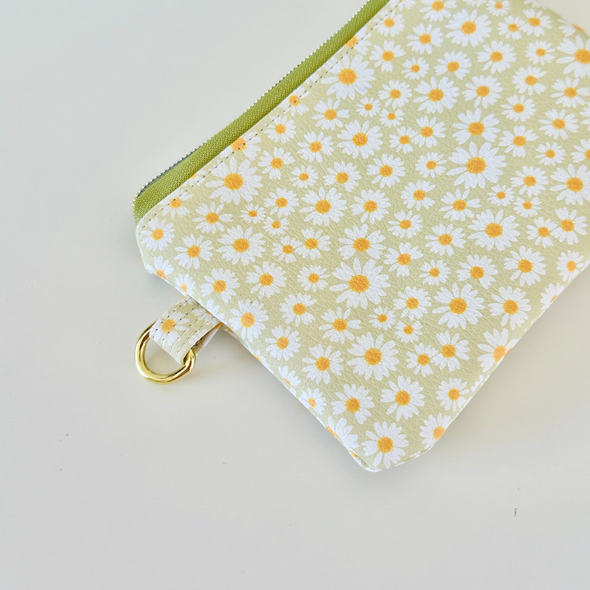 green daisy Floral-patterned coin purse  with coins and cards on a light background