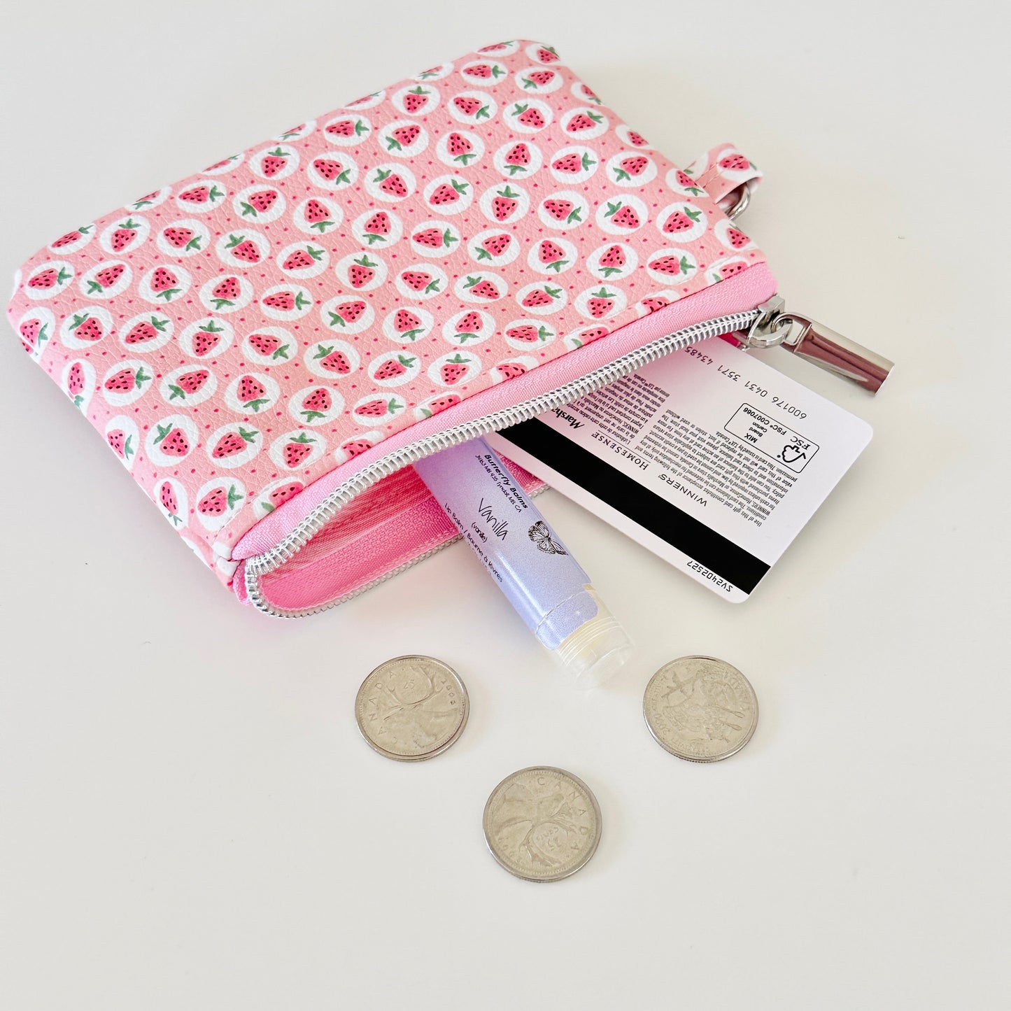 Pink strawberry coin purse on a white background