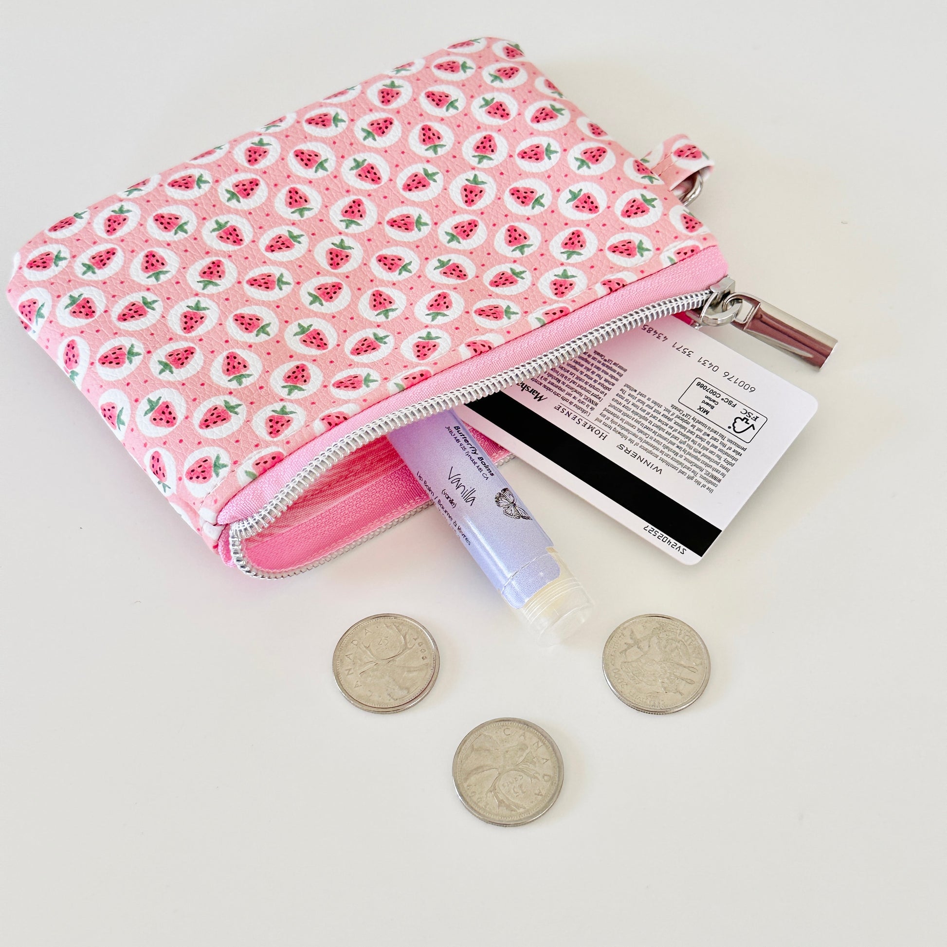 Pink strawberry coin purse on a white background