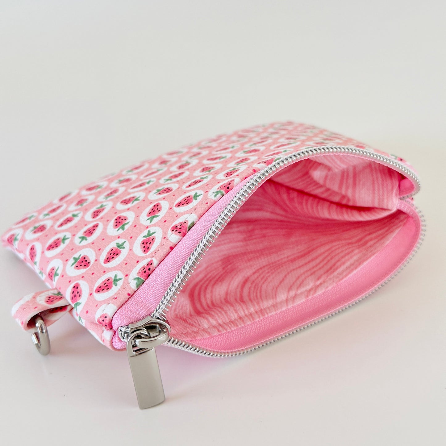 Pink strawberry coin purse on a white background