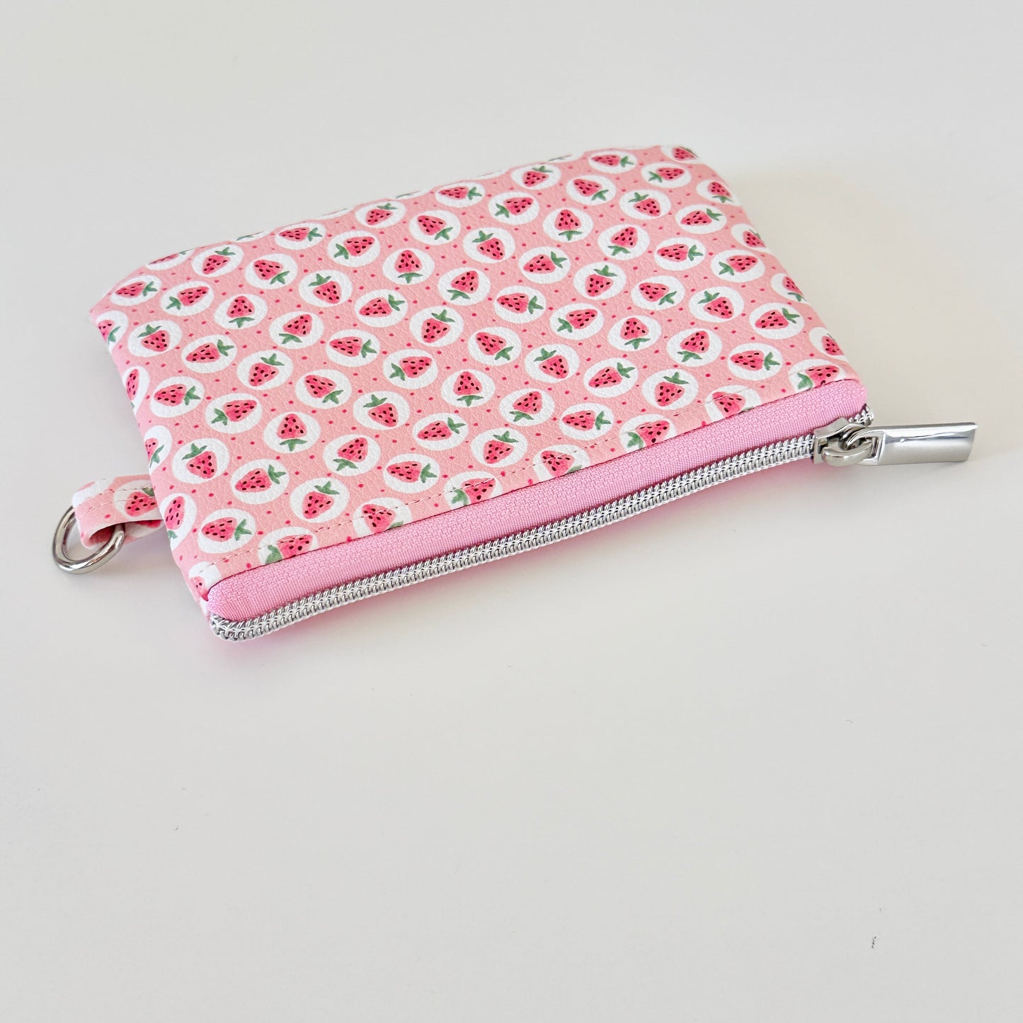 Pink strawberry coin purse on a white background