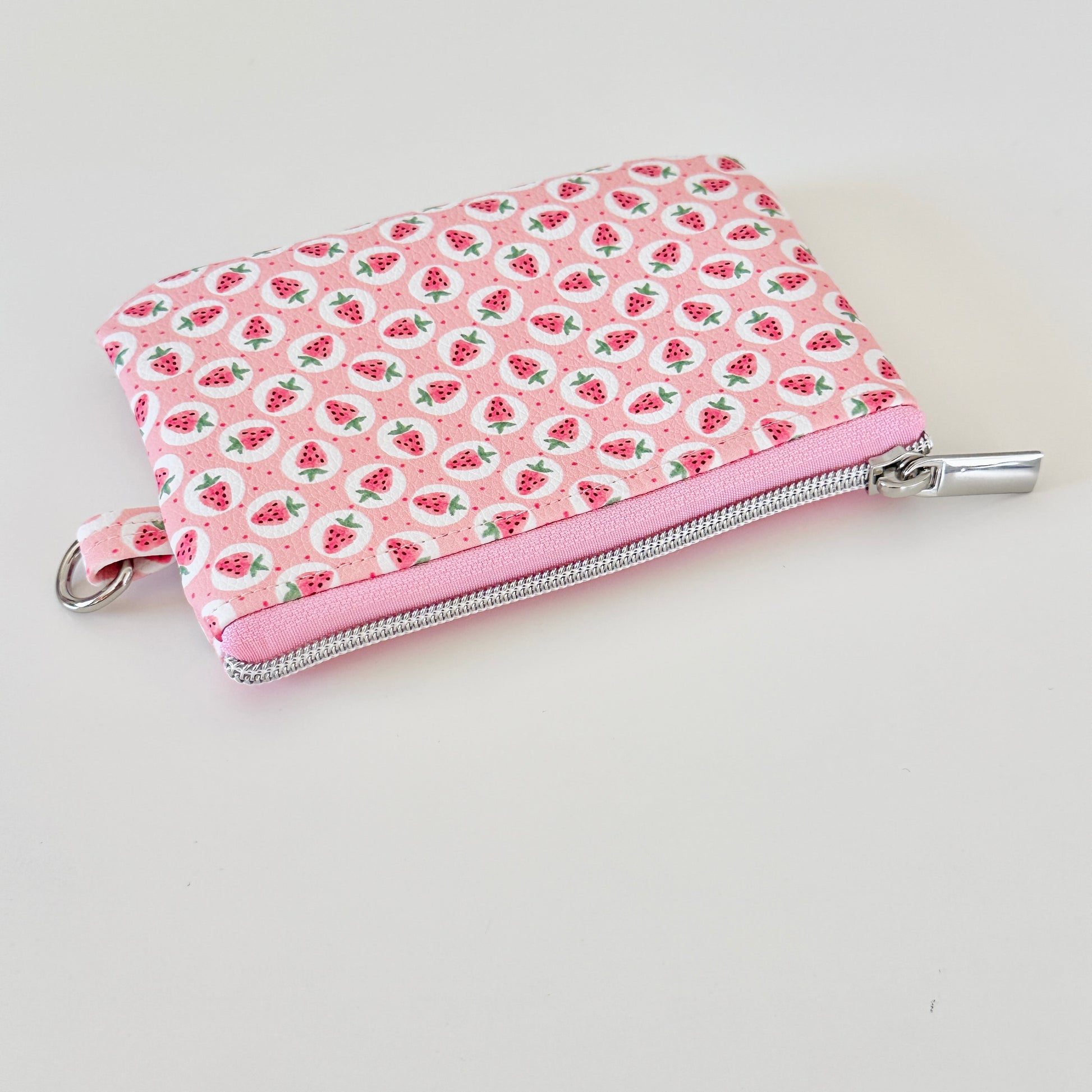 Pink strawberry coin purse on a white background