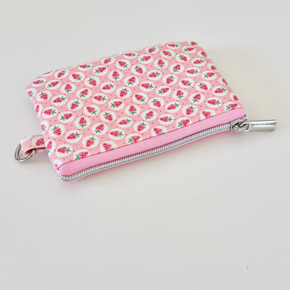 Pink strawberry coin purse on a white background