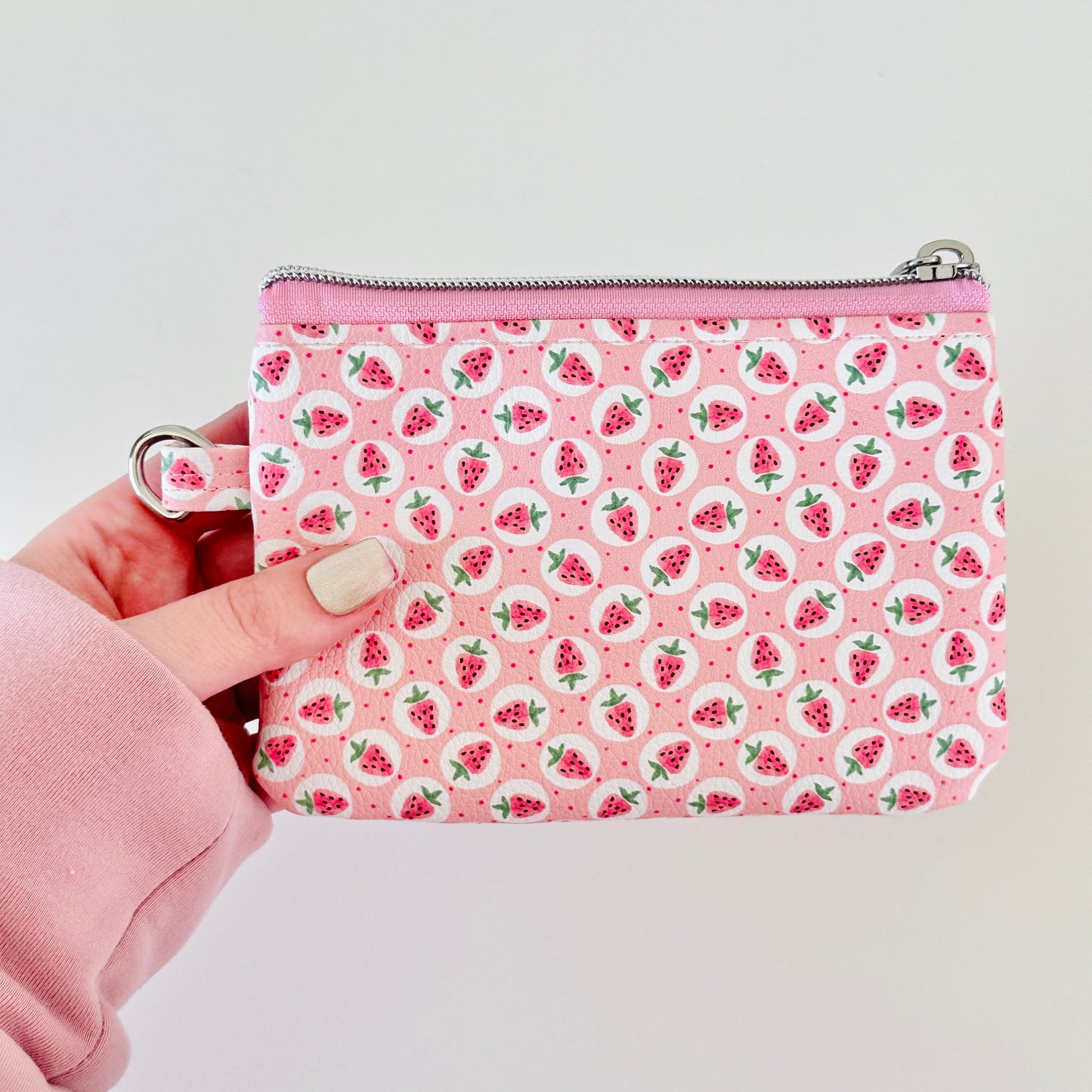 Pink strawberry coin purse on a white background