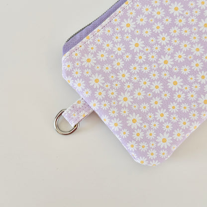Purple floral-patterned coin purse with coins on a light gray background