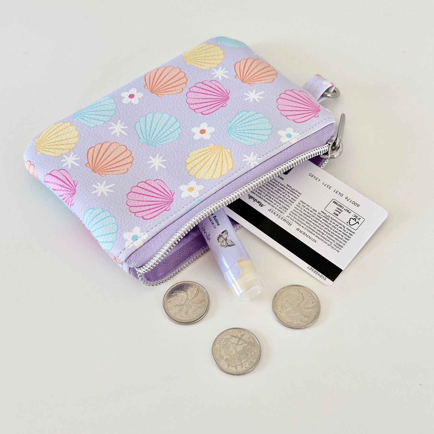 purple vegan leather coin purse with seashell pattern on a white background