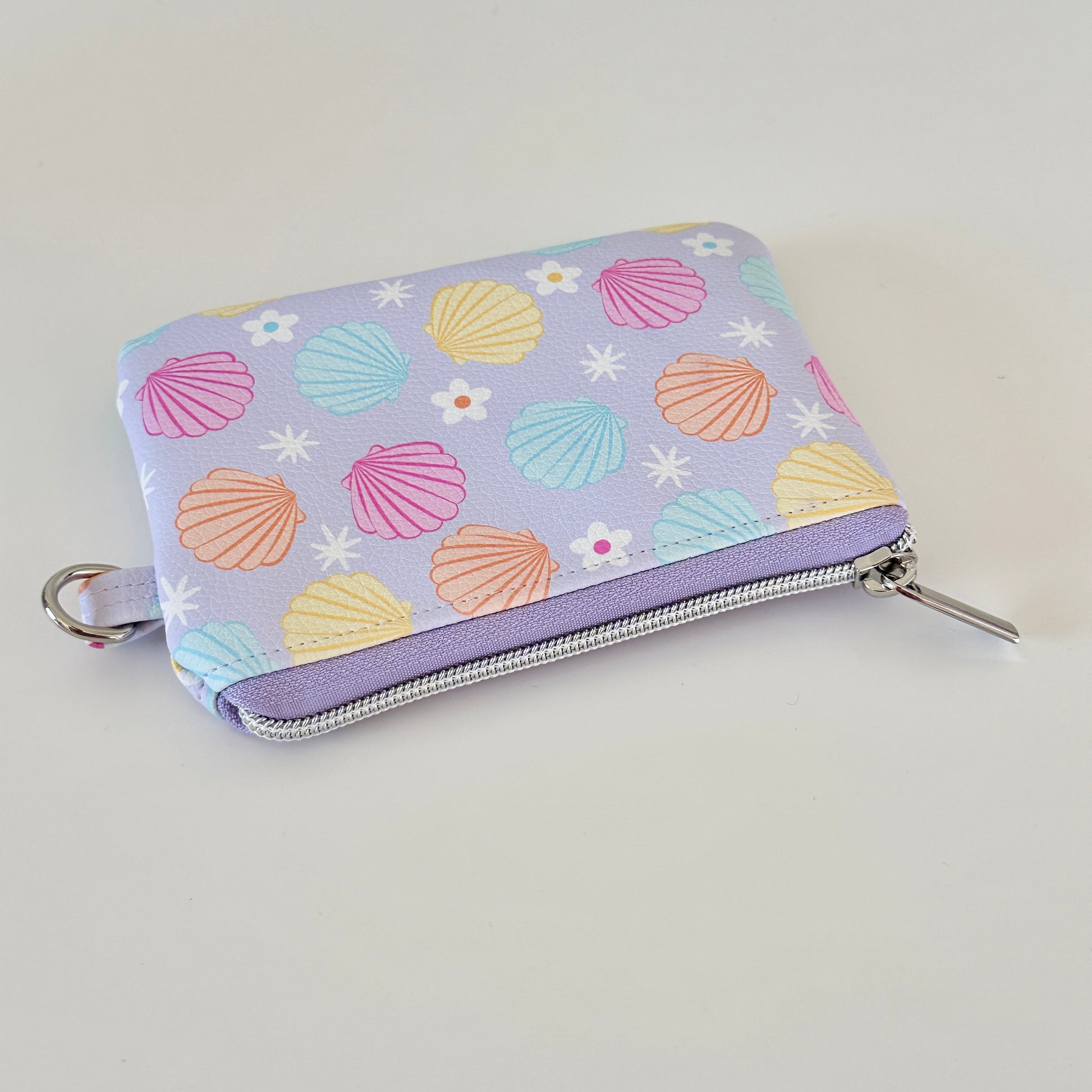 purple vegan leather coin purse with seashell pattern on a white background